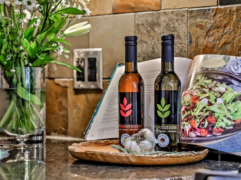 a granite countertop in a vacation rental at Spring Creek Vacations with two bottles of olive oil atop it and a cook book propped up behind them.