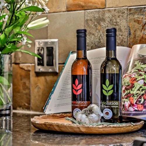 a granite countertop in a vacation rental at Spring Creek Vacations with two bottles of olive oil atop it and a cook book propped up behind them.