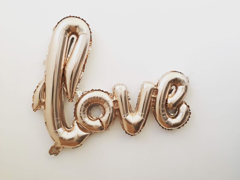 The word 'love' in a rose-gold balloon