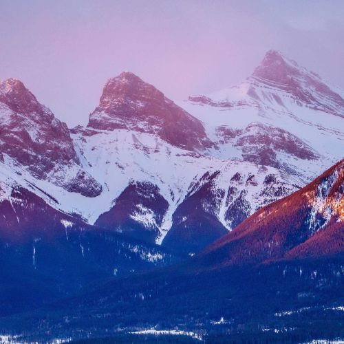A sunrise over the snowcapped Three Sisters mountains in Canmore, Alberta.
