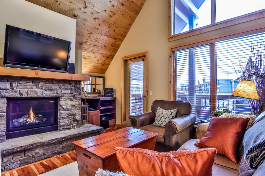 living room with fireplace and tv in #310 Rundle Cliffs Lodge