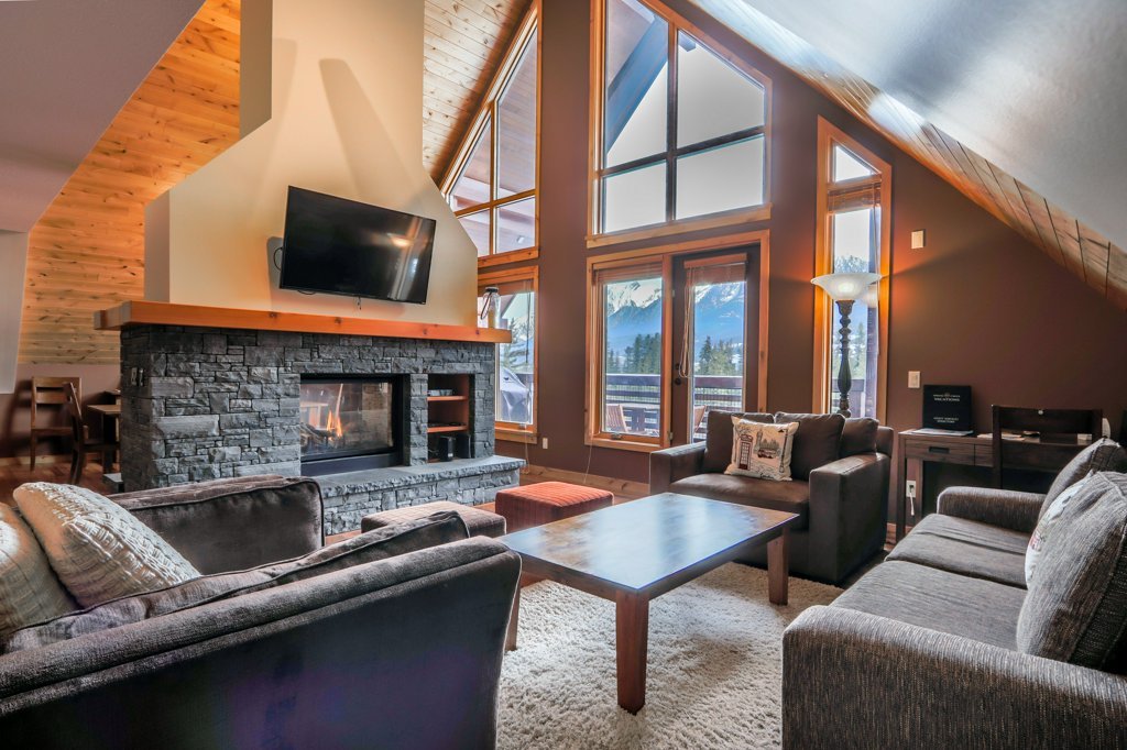 living room with fireplace and balcony access in #401 Rundle Cliffs Lodge