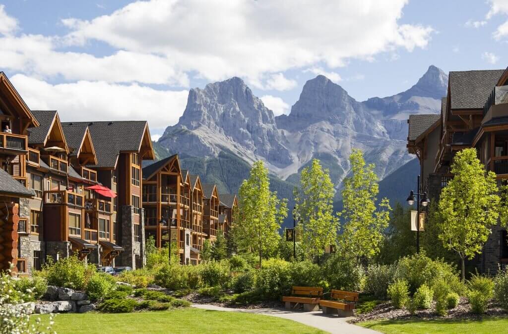The paths and luscious gardens that surround Spring Creek, with a view of the Canadian Rocky Mountains and the Three Sisters peaks in Canmore.