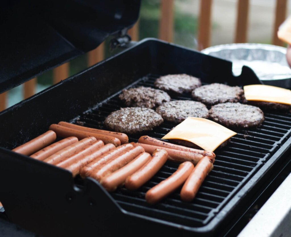 A family burger and hot dog night with burgers and hot dogs being cooked on a barbecue, perfect for a meal while on a family vacation in Canmore.