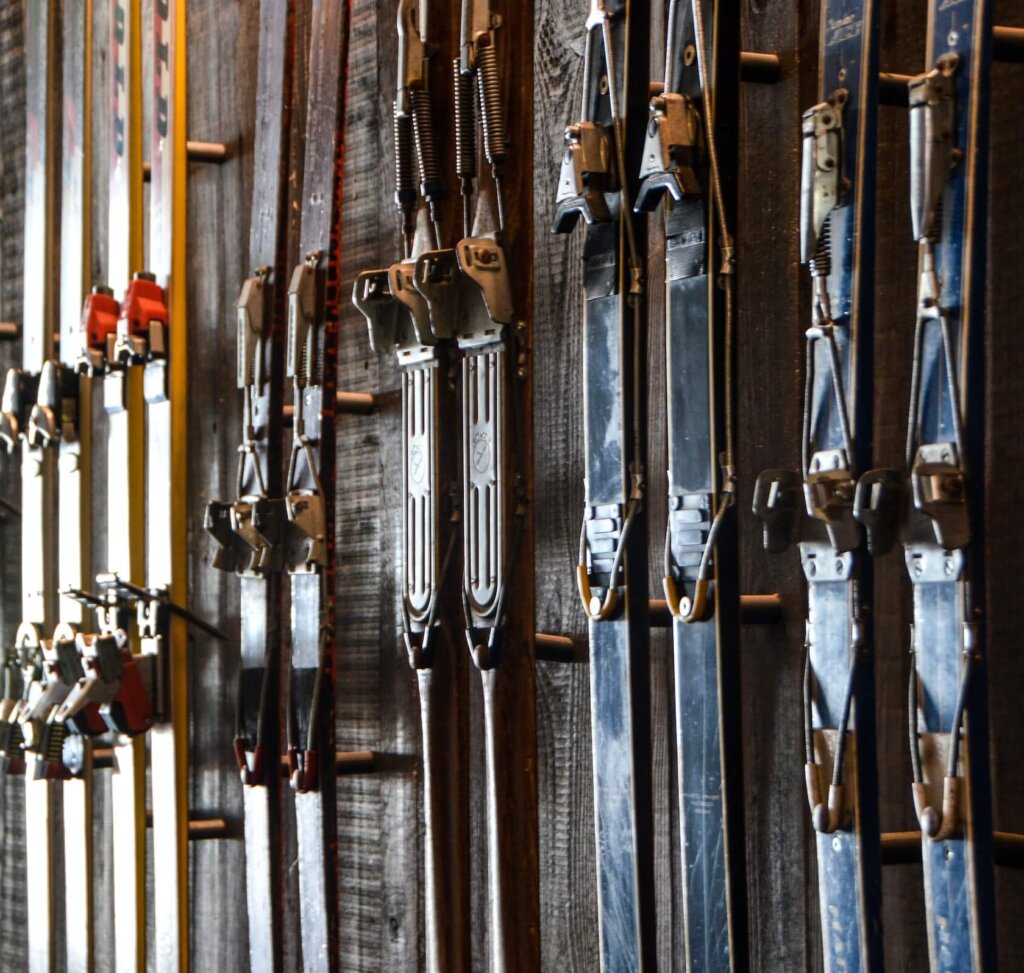 A row of lined up skis hang on a shop's wall.
